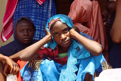 这张特写照片是一名妇女穿着传统服装，抱着头